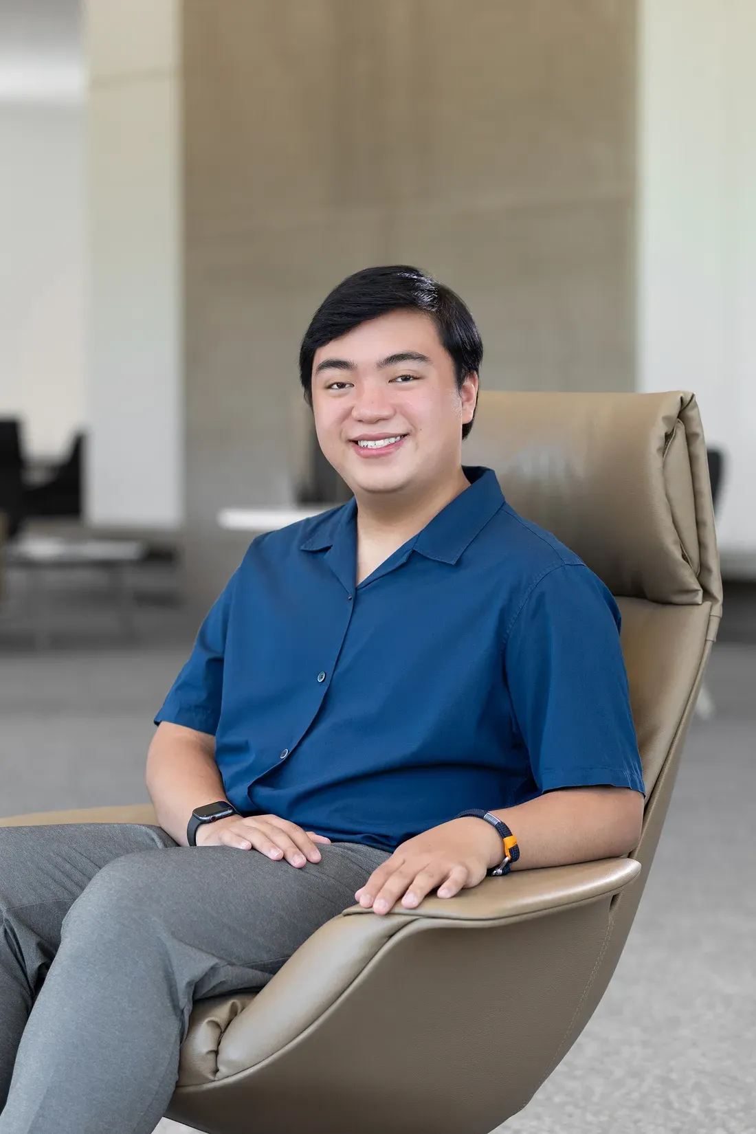 Enrique Prejula sitting in a chair and smiling.